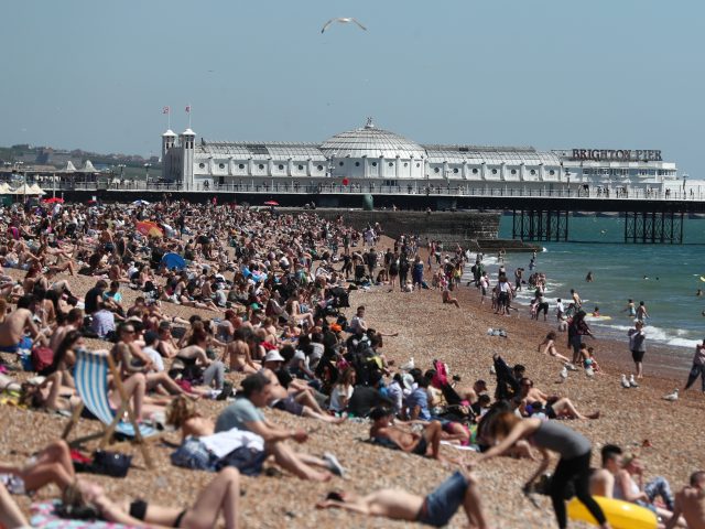 Sunbathers enjoy the warm weather on Brighton Beach (Gareth Fuller/PA)