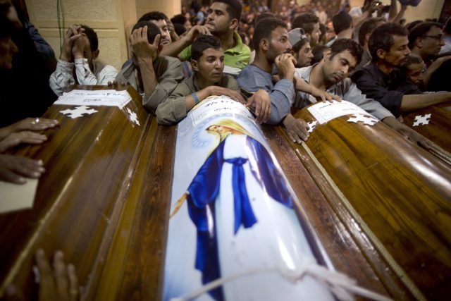Relatives of Coptic Christians who were killed during a bus attack, surround their coffins, during their funeral service, at Abu Garnous Cathedral in Minya (Amr Nabil/AP)