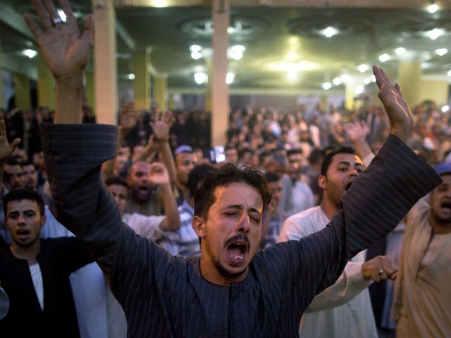 Crowds shout slogans during a funeral service in Minya, Egypt (Amr Nabil/AP)