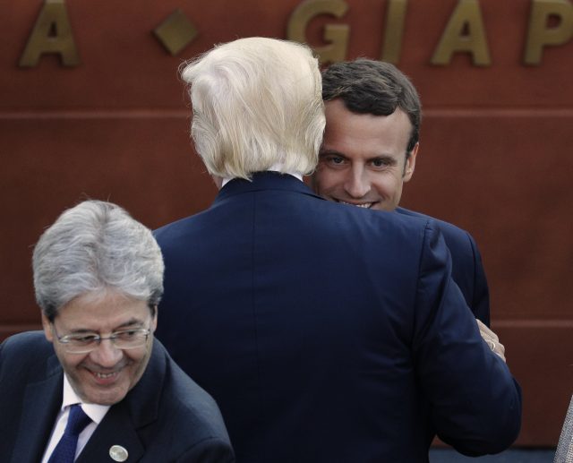 Mr Macron and Mr Trump embrace  during a social evening at the G7 summit (Andrew Medichini/AP)