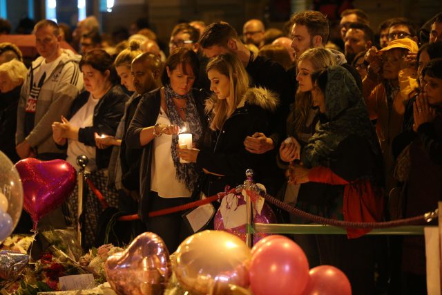 Mourners light candles and pause for a minute's silence in St Ann's Square, Manchester