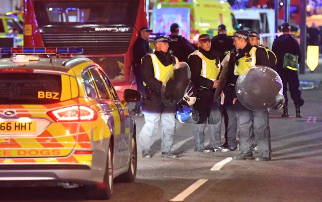 Police officers with riot shields are on Borough High Street