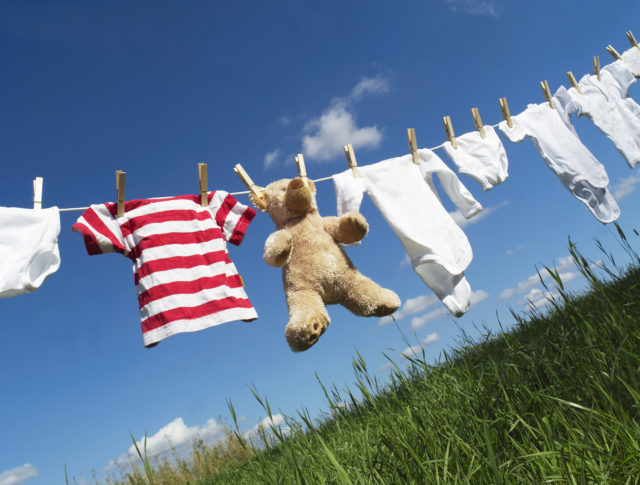 (ThinkStock/PA) Baby Clothing and a teddybear on a clothesline towards blue sky