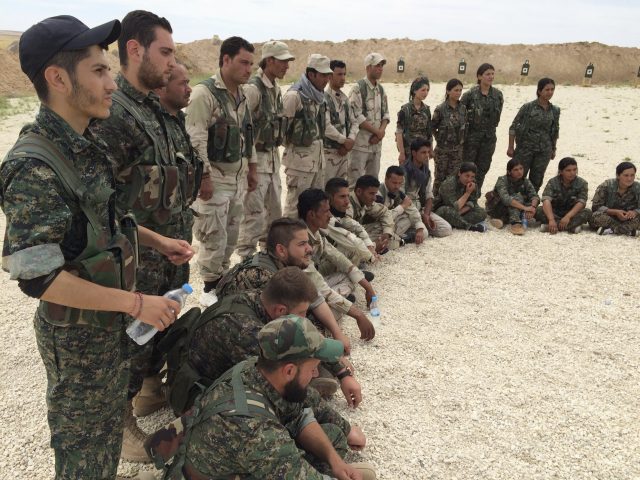 Members of the Syrian Democratic Forces gather after a training session at a firing range in northern Syria