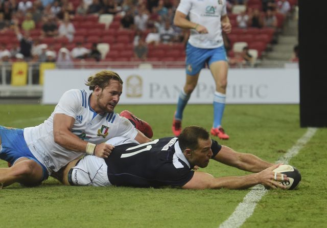 Scotland's Tim Visser scores a try past Italy's Andrea Lovotti at Singapore's National Stadium (Joseph Nair/AP)