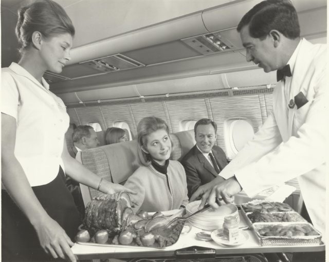Customers being served meat at their seat on a BOAC flight in the 1970s