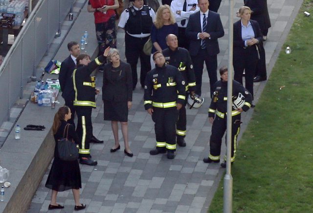 Mrs May and firefighters look up to the tower. (Rick Findler/PA)