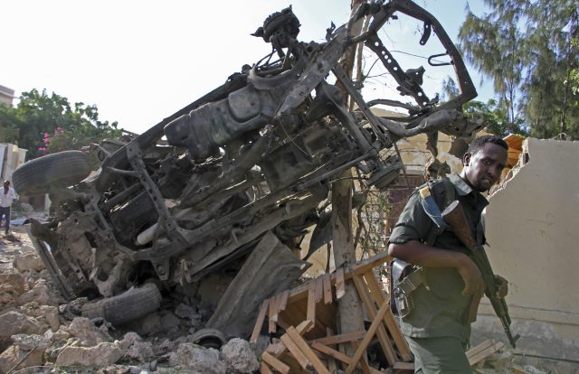 A Somali soldier stands near the wreckage. (PA)