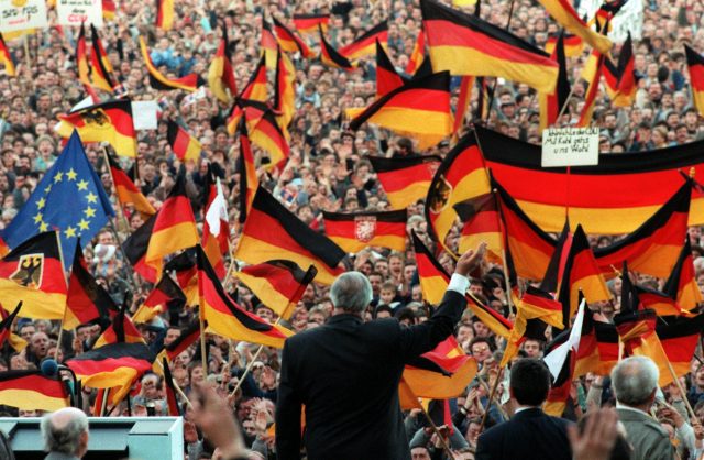 Helmut Kohl is framed by German flags as he waves to spectators during a campaign rally in Erfurt