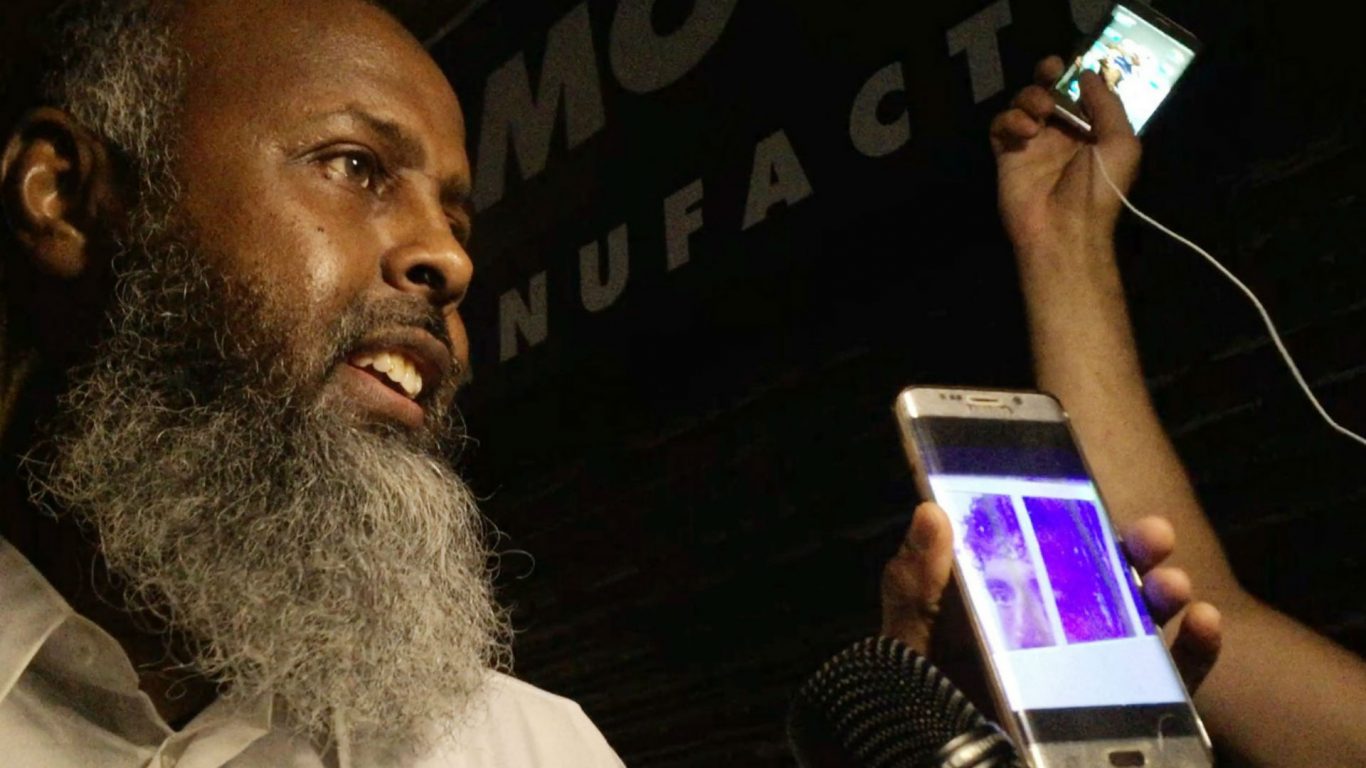 Witness Abdikadar Warfa shows reporters a picture of a man who he says was taken away by police after an incident in Finsbury Park (Alex Britton/PA)