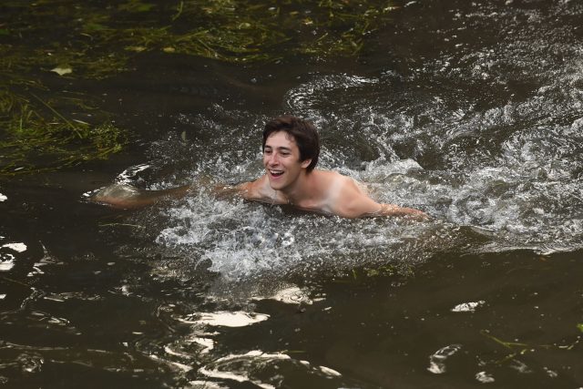 A student swims in the River Cam after celebrating the end of the academic year