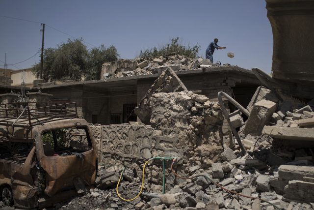 An Iraqi man removes rubble from his damaged house in a neighborhood recently retaken by Iraqi security forces during fights against Islamic State militants in Mosul (Felipe Dana/AP)