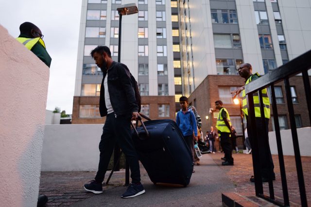 Residents leave the Taplow tower block on the Chalcots Estate (Stefan Rousseau/PA)