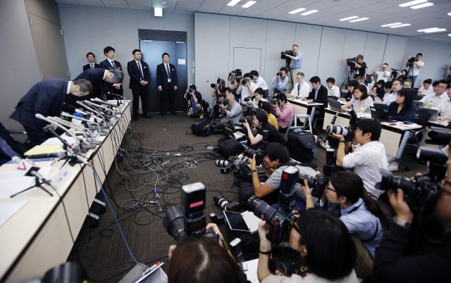 Japanese air bag maker Takata Corp. CEO Shigehisa Takada, left, bows during a press conference in Tokyo (Shizuo Kambayashi/AP)