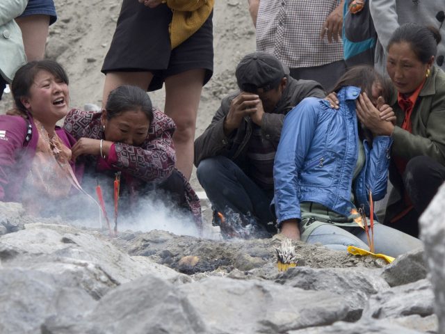 Relatives mourn after landslides left more than 100 people buried (Ng Han Guan/AP)