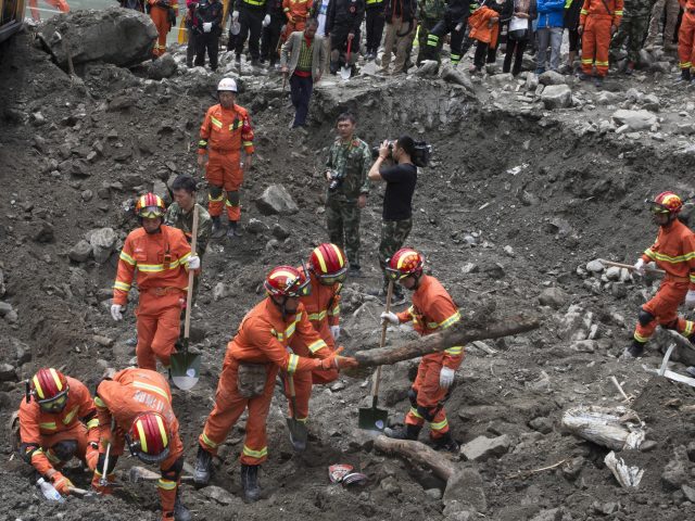 Rescue workers search for victims (Ng Han Guan/AP