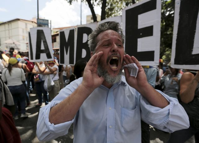 A man shouts slogans against Mr Maduro (Fernando Llano/AP)