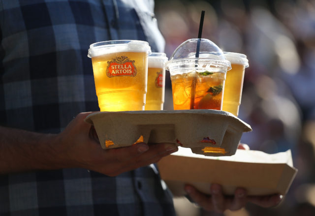 A spectator carries drinks on Murray mount watching Andy Murray playing on day five of the Wimbledon Championships at the All England Lawn Tennis and Croquet Club, Wimbledon.