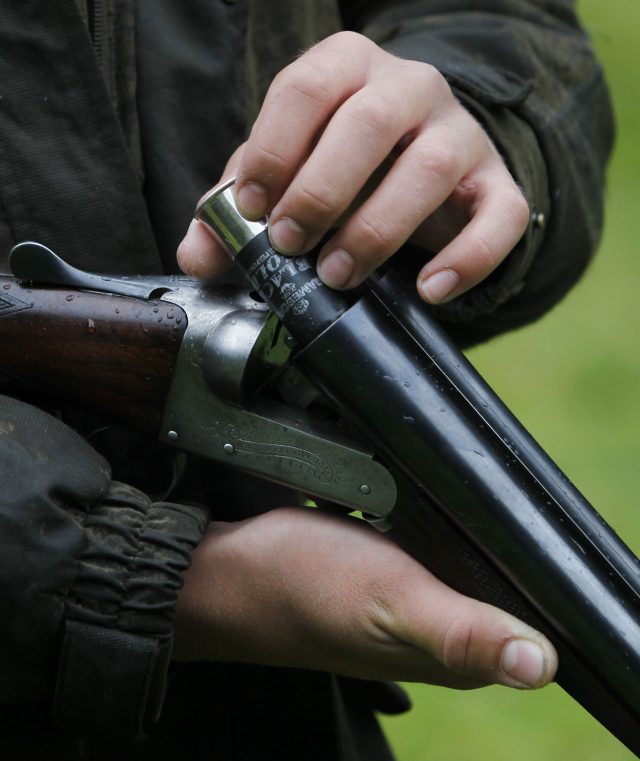 A Grouse shooter loads a cartridge into his shotgun. (PA)