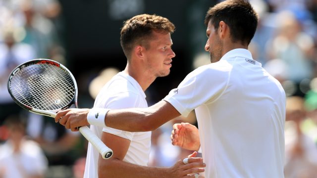 Novak Djokovic and Adam Pavlasek meet at the net after their second round match