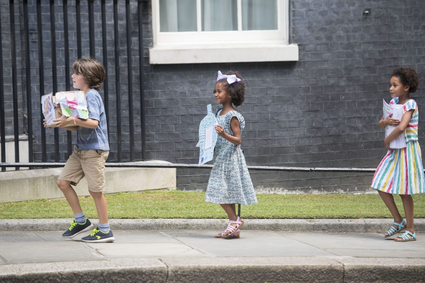 Johnny Miller-Cole, Suzie Ali and Leonie Ali deliver the messages to 10 Downing Street (Victoria Jones/PA)