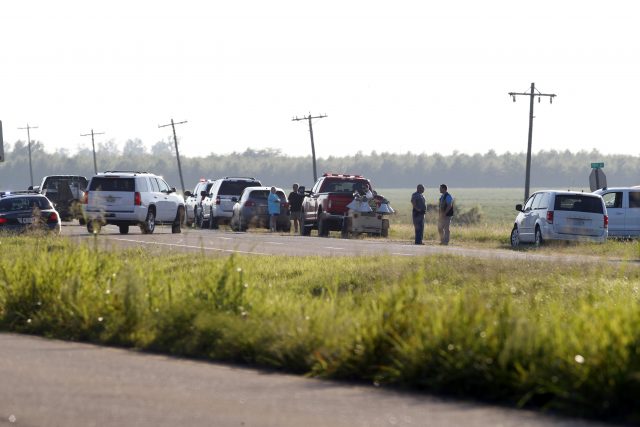 Emergency personnel stand along Highway 82 after a military transport plane crashed into a field near Itta Bena (Andy Lo/AP)
