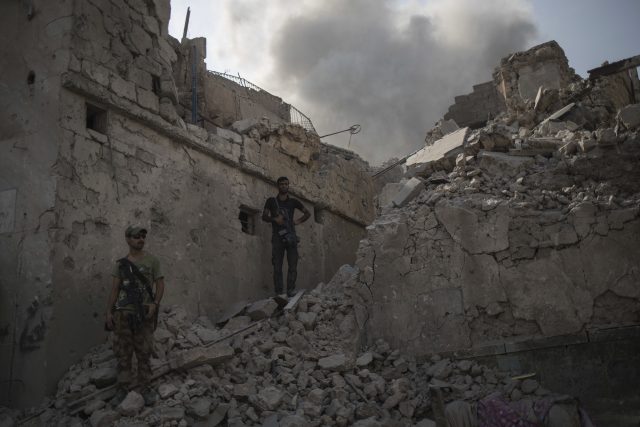 Iraqi Special Forces soldiers stand on the rubble of a damaged building in Mosul (Felipe Dana/AP/PA)