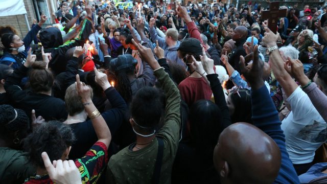 People attend a vigil to mark four weeks since the Grenfell Tower fire