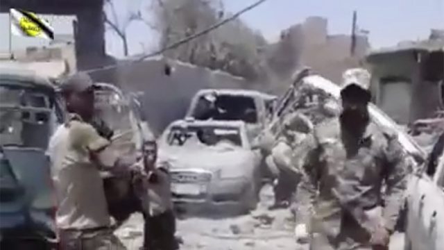 This photo made from undated video posted online shows a man in an Iraqi Army uniform moments before shooting an unarmed man in Mosul 