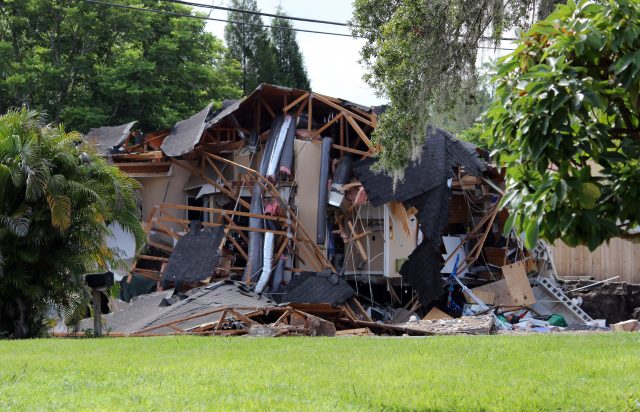 Debris is strewn about from a partially collapsed home in Land O' Lakes, Fla. on Friday, July 14, 2017.A sinkhole that started out the size of a small swimming pool and continued to grow has swallowed a home in Florida and severely damaged another