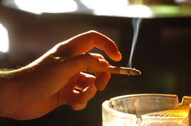 A man holds a cigarette