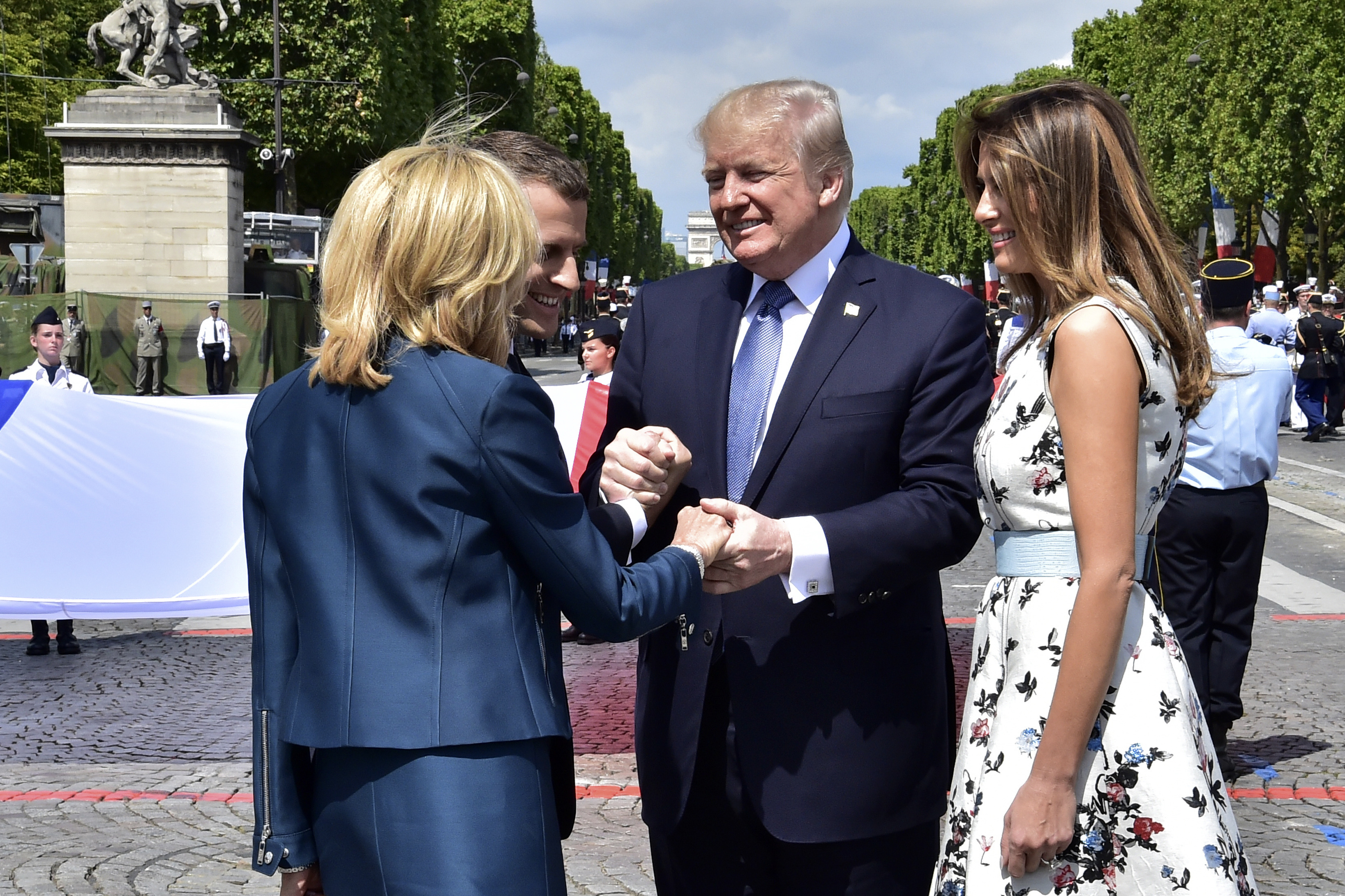 French President Emmanuel Macron, second left, shakes hands with U.S President Donald Trump while First Lady Melania Trump and Brigitte Macron, left, walk on sides after the Bastille Day military parade on the Champs Elysees avenue in Paris Friday, July 14, 2017. France's annual Bastille Day parade turned into an event high on American patriotism this year, marked by a warm embrace between President Donald Trump and his French counterpart. (Christophe Archambault, Pool via AP)