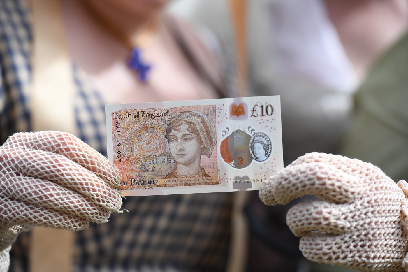 People in period costume with the new £10 note featuring Jane Austen, which marks the 200th anniversary of Austen's death, during the unveiling at Winchester Cathedral.