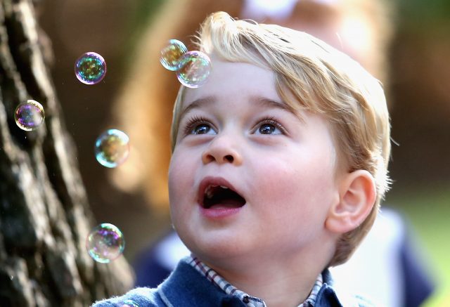 Prince George plays with bubbles at a children's party