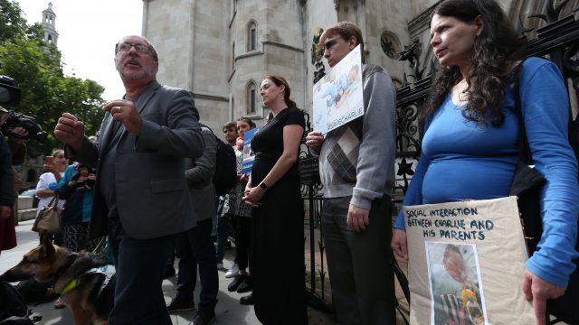 Rev. Patrick Mahoney (left) from Washington and friends of Charlie Gard's family outside the Royal Courts