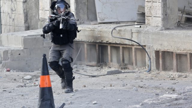An Israeli police officer takes aim during clashes near the Qalandia checkpoint