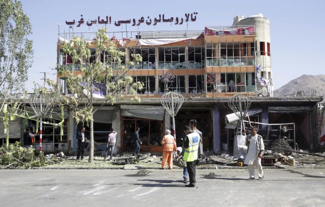 City workers clean up in front of a wedding hall in Kabul after the blast (Massoud Hossaini/AP)