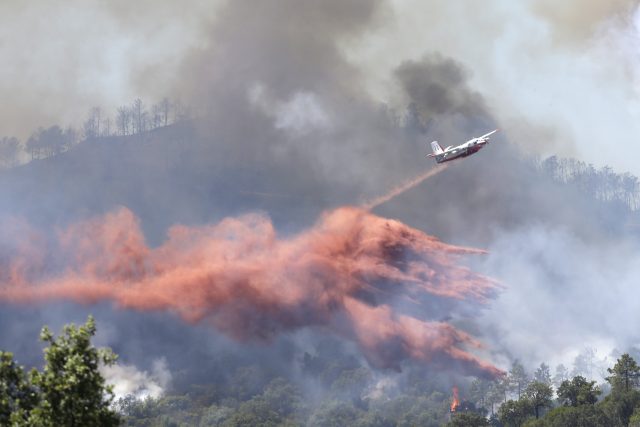 A plane drops fire retardant