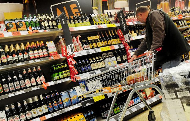 A customer looks at alcohol on the shelf at a supermarket