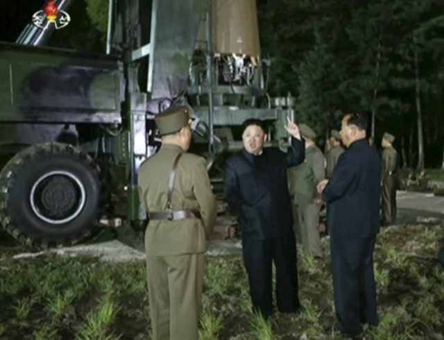 In an image taken from video, Kim Jong Un gestures at the site of the missile test (KRT via AP)