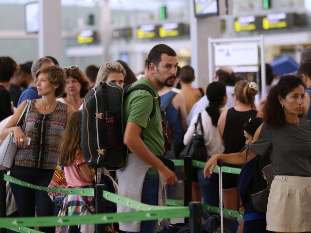 Passengers queue at Barcelona Airport