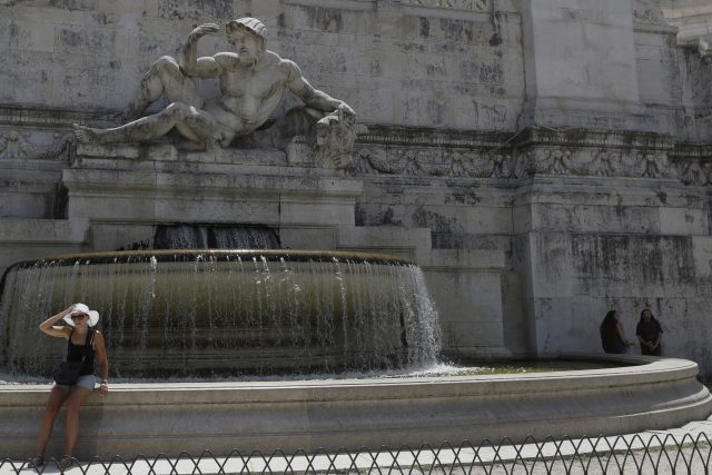A woman sits near the Fountain of the Adriatic Sea in Rome 