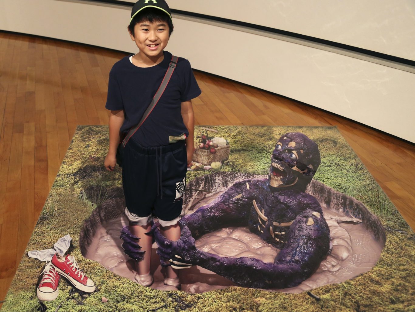 A boy poses with a 3D image at a 3D trick art exhibition by Japanese artist Masashi Hattori in Kawasaki, near Tokyo, Saturday, Aug. 5, 2017. (Koji Sasahara/AP/PA