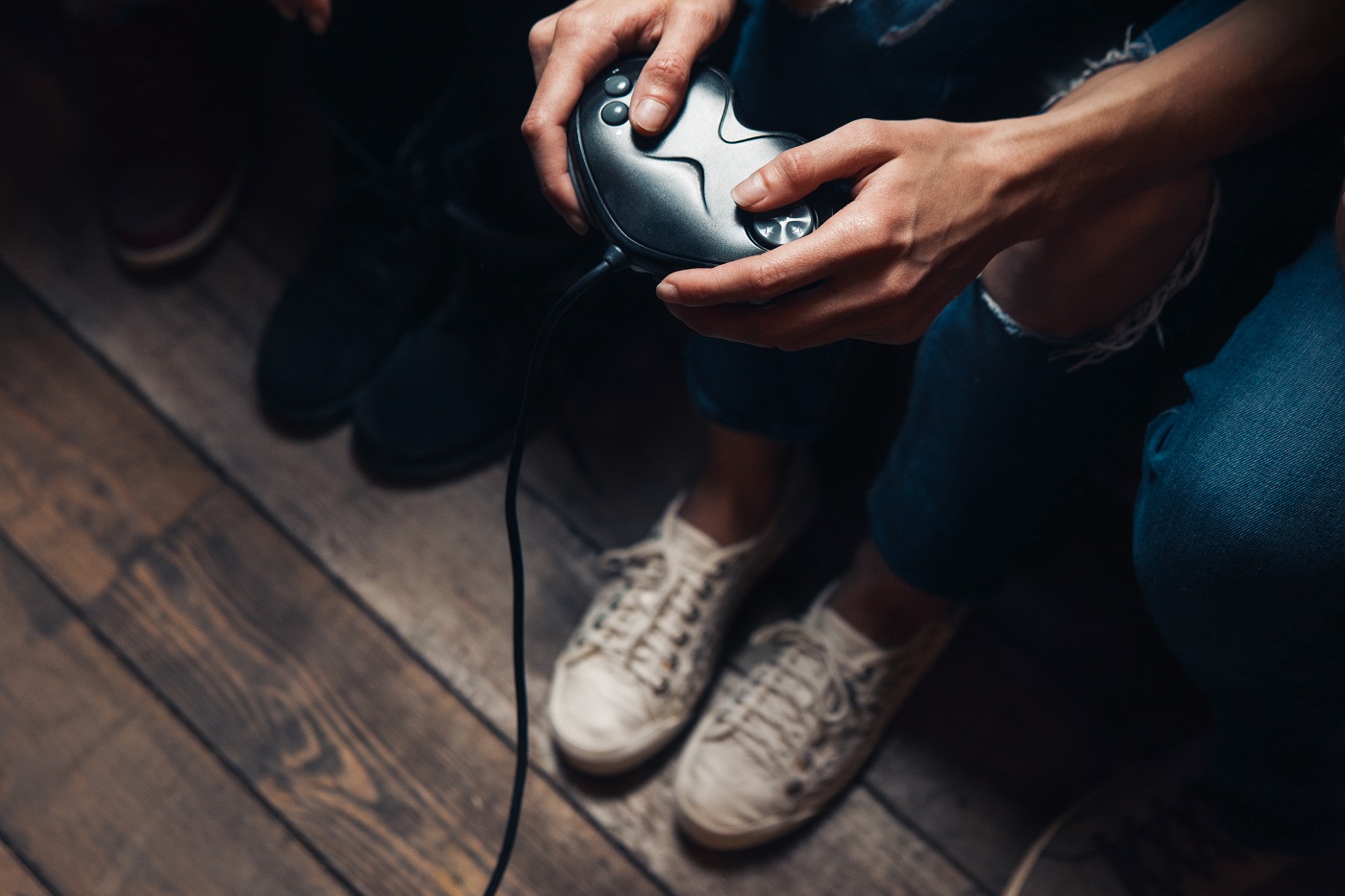 Video game addiction, psychological disorder excessive play, everyday unhealthy lifestyle. Closeup view of unrecognizable person hands with joystick.