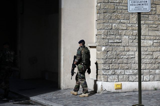 A French soldier patrols near the scene