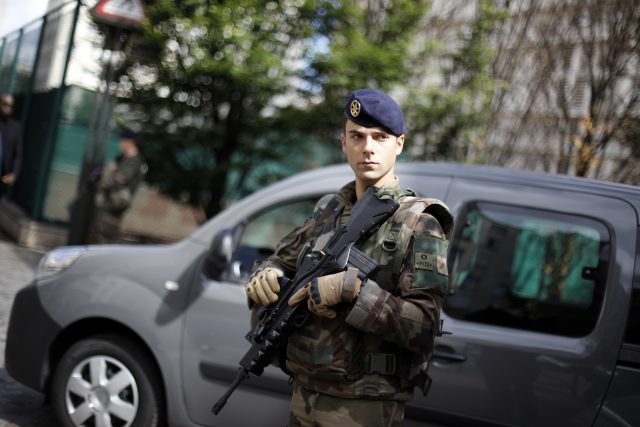 A French soldier stands near the scene where French soldiers were hit and injured by a vehicle in the western Paris suburb of Levallois-Perret (Kamil Zihnioglu/AP)