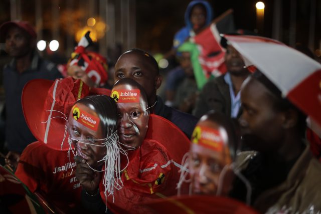 A man carries masks with the image of Kenya's President Uhuru Kenyatta