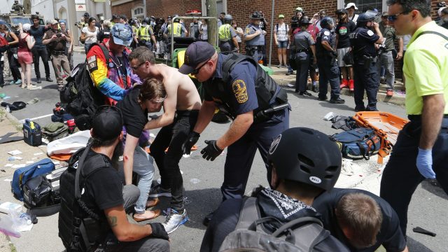 Rescue personnel help injured people after a car ran into a large group of protesters after a white nationalist rally in Charlottesville