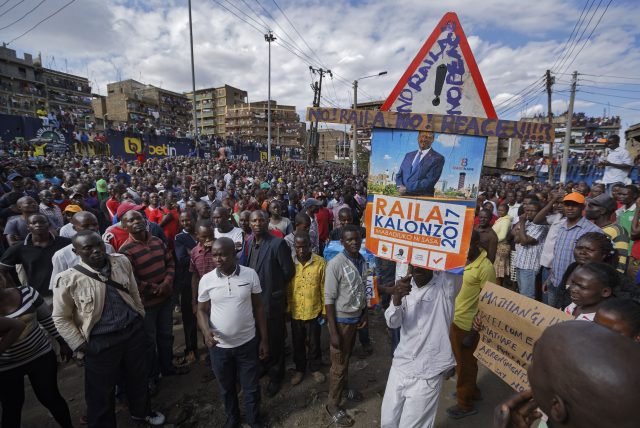 A supporter carries a placard showing Kenyan opposition leader Raila Odinga, with the message 
