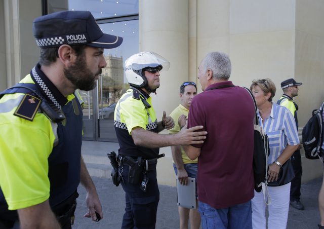 Police officers tell members of the public to leave the scene in a street in Barcelona